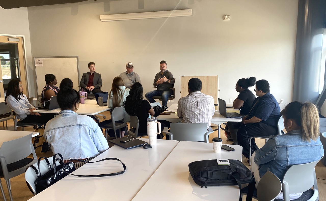 Corewell Health’s Aaron Bregg (right) speaks to students about trends in cybersecurity on a panel alongside Acrisure’s Anthony Coggins (left) and West Michigan Cloud Security Alliance’s Matt Nelson (center). 